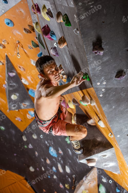 Preview: Young male rock climber in indoor climbing gym