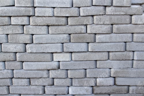 Visualização: ladrilhos de tijolos empilhados em um palete. Tijolos de pavimento cinza para estradas pavimentadas. Pilha pedras de pavimentação empilhadas