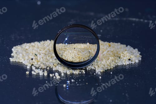 Preview: Closeup of an ammonium iron sulfate on a glass surface near a lens