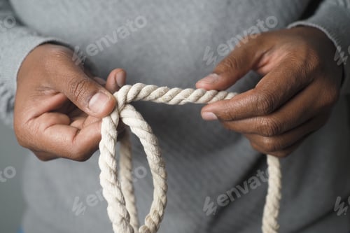 Preview: Hands manipulating a rope during a crafting session indoors