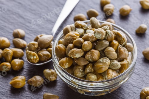 Preview: pickled capers on a dark stone background