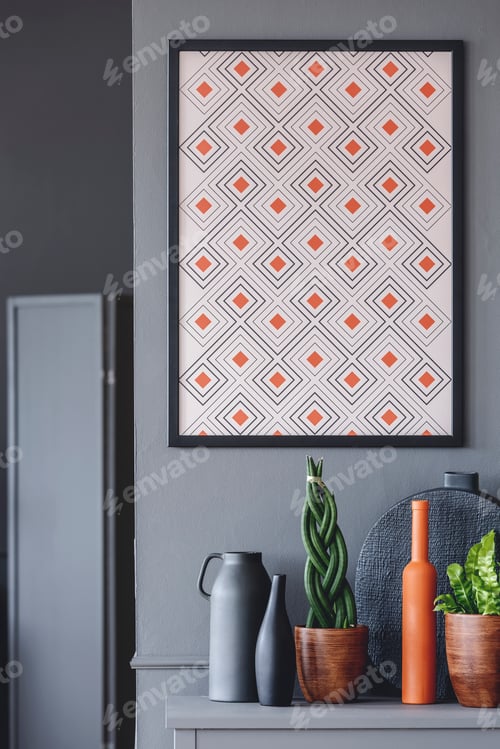 Preview: Geometrical poster with orange accents on the wall above plants