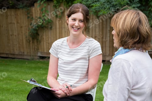 Preview: Woman and female therapist at an alternative therapy session in a garden.