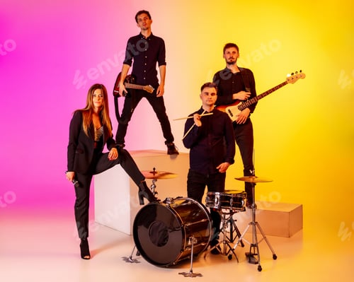 Preview: Young caucasian musicians, band performing in neon light on gradient studio background