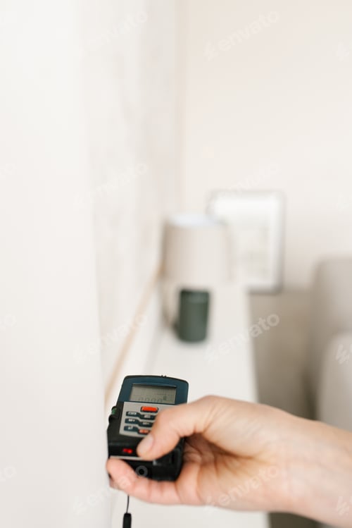 Preview: Laser Rangefinder in the Hands of a Woman Near a Wall