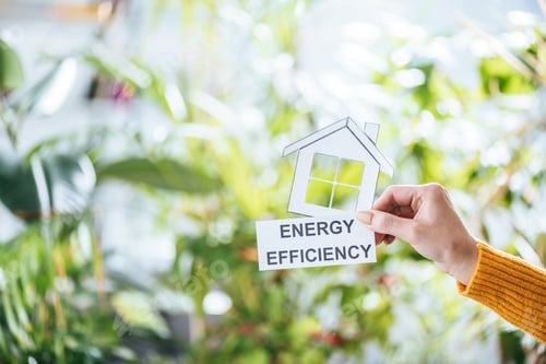 Preview: selective focus of woman holding paper house and card with lettering, energy efficiency at home