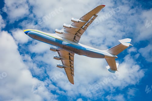 Preview: A large cargo plane flies in the blue sky. Aviation air transport. Airplane symbol.