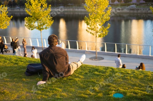 Preview: People Relax in Public Park with Lake and Green Trees with Skyscrapers Buildings in the City on Back