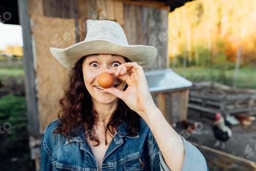 Preview: With a beaming smile, a hobby woman farmer displays a perfect egg