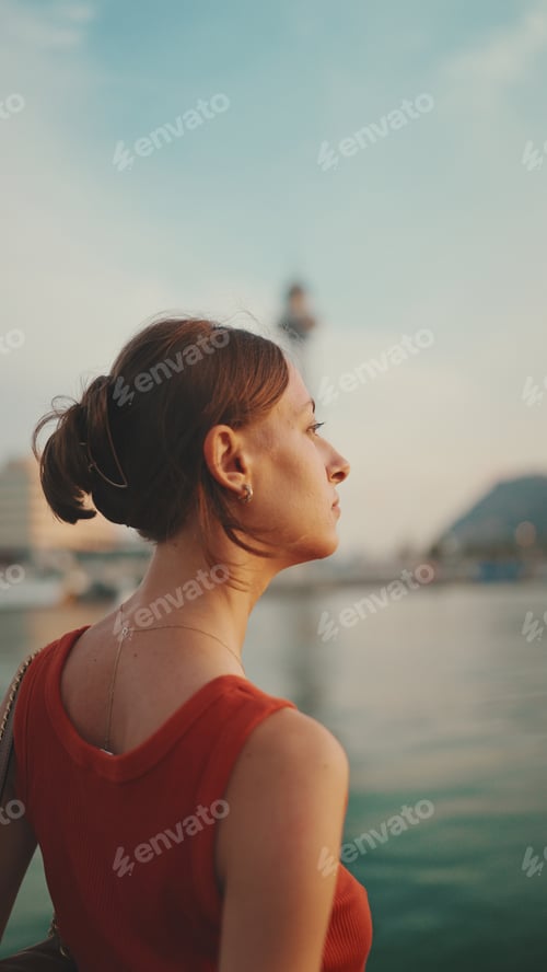 Preview: Girl stands on the embankment and looks at the bay