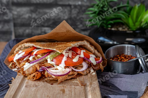 Preview: Turkish kebab with chicken doner meat on a wooden board.