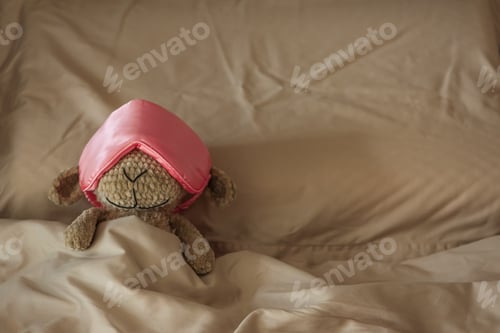 Preview: Knitted Sheep Toy Sleeping with Satin Mask on Cozy Bed