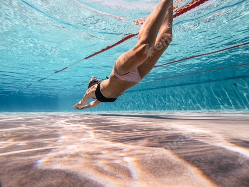 Preview: Woman Swimming Underwater in a Blue Pool