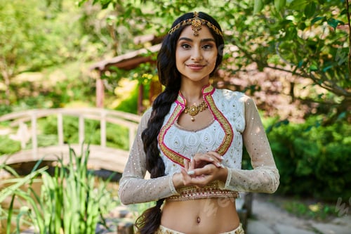 Preview: portrait of attractive indian woman in traditional attire smiling at camera in park