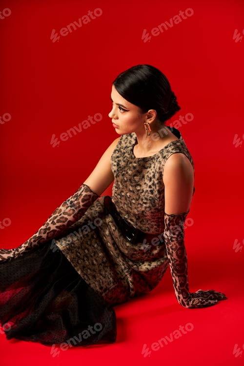 Preview: Fashionable Woman in Leopard Print Dress Posing Against Red Background