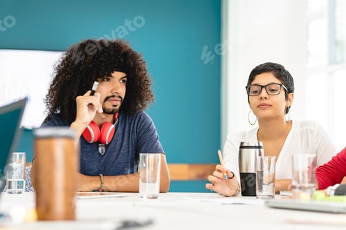 Preview: Diverse colleagues at table during meeting