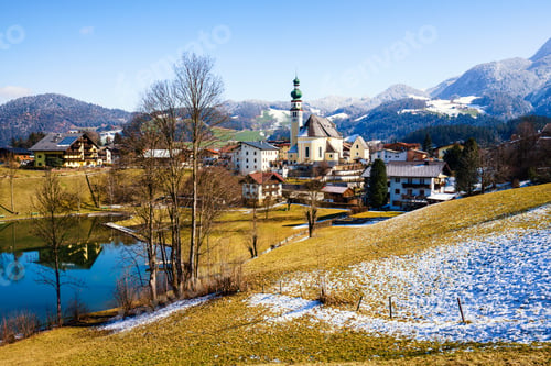 Preview: Beautiful shot of a small village surrounded by a lake and snowy hills