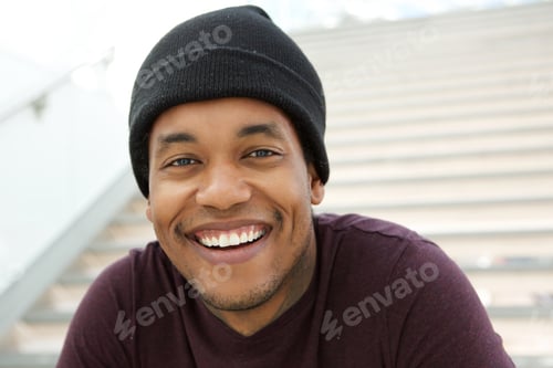 Preview: Close up cool young black man with beanie smiling