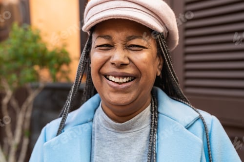 Preview: Happy senior African woman having fun looking in front of a camera in the city