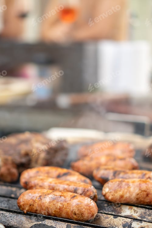 Preview: Pork sausages cooked on a grill barbecue in a garden