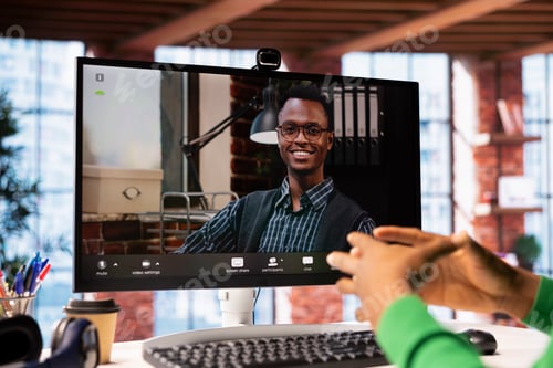 Preview: Man at home engaging in a video call with smiling psychologist using PC