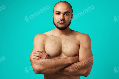 Preview: Young black man bodybuilder with naked torso standing with his arms crossed