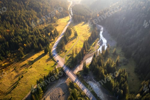 Preview: Aerial view of mountain road and beautiful forest at sunset