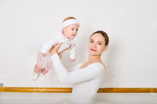 Preview: Young ballerina mother holding baby daughter in dance studio