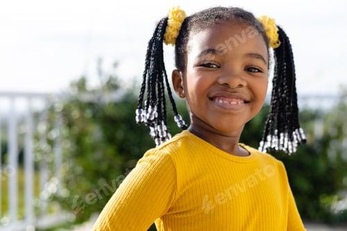 Preview: Portrait of happy african american girl staying on sunny terrace
