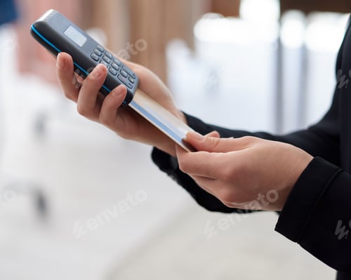 Preview: Closeup shot of an unrecognisable woman using a credit card machine in a store
