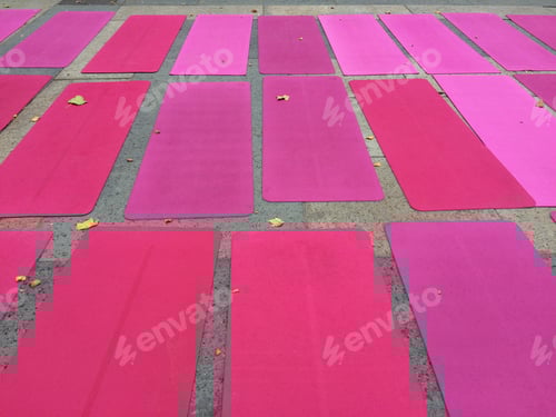Preview: Pink Yoga Mats Arranged on Grey Stone Surface