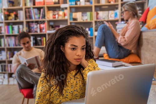 Preview: Portrait of young African American female student study in the library.