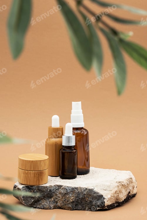 Preview: Glass and Bamboo Essential Oil Bottles with Pipette, Spray Bottle and BambooJar on Stone Podium.