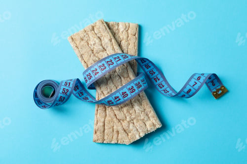 Preview: Measure tape and diet bread on blue background