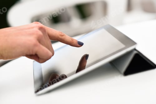 Preview: Woman's hand touching a tablet computer