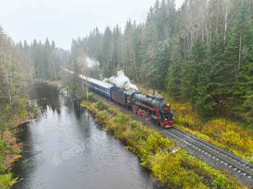 Preview: Vintage steam train moving through forest along a river