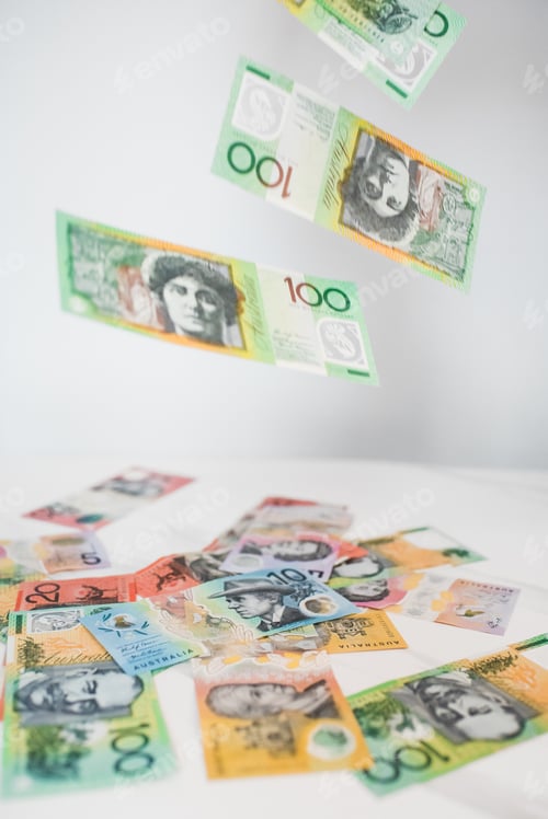 Preview: Vertical shot of Australian dollar banknotes on the ground and in the air on the white background