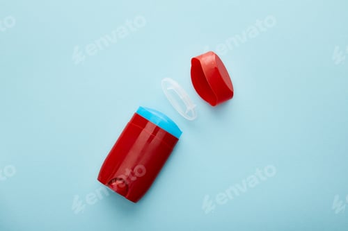 Preview: top view of red roll on bottle of deodorant on blue background