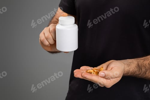 Preview: Man holding a bottle and supplements in hand