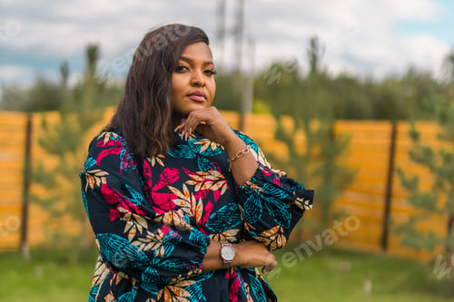 Preview: Summer portrait of beautiful african american woman in colourful dress wear standing on backyard