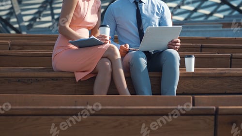 Professionals Work Together Outdoors with Technology and Coffee