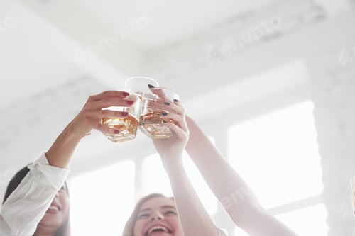Preview: Whiskey glasses into the air. Girls having party with alcohol