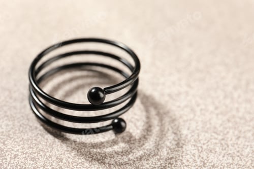 Preview: Stylish black ring on pink textured surface, closeup. Space for text