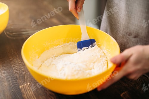 Preview: Woman in apron stir the dough on wooden table
