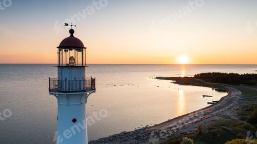 Preview: Aerial view to the top of the historic lighthouse on the setting sun background at the Baltic Sea