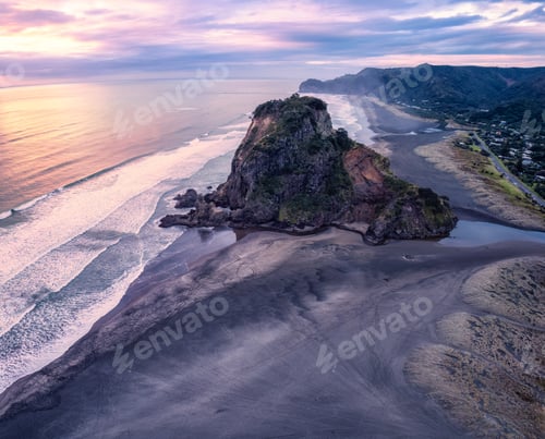 Preview: Beautiful iconic Lion Rock and breaking wave on Piha beach in the evening at Auckland, New Zealand