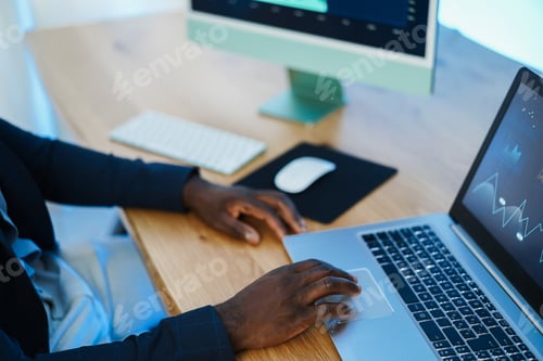 Preview: African trader studying stock market at home - Focus on right hand
