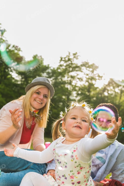 Family Plays Together Blowing Bubbles in the Sunlight