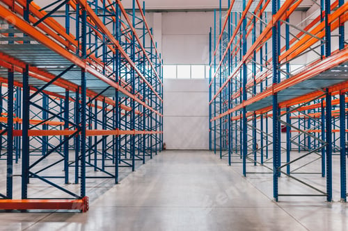 Preview: Empty Industrial Warehouse With Large Orange and Blue Storage Racks