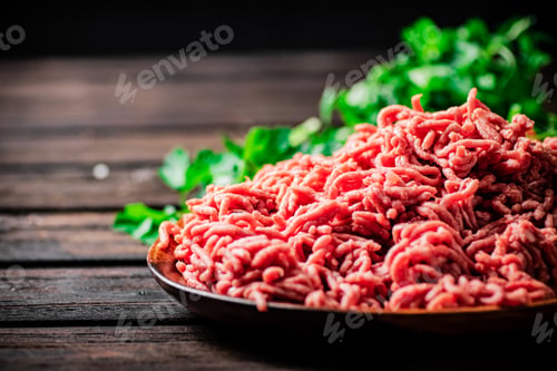 Preview: Minced meat on a plate on the table with parsley.